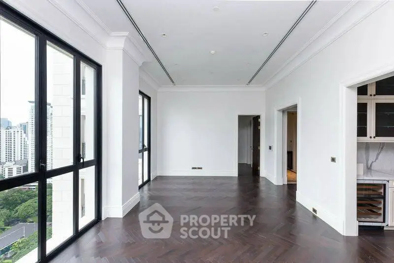 Spacious modern living room with large windows and elegant wooden flooring in a high-rise apartment.
