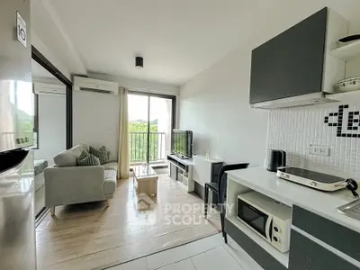 Modern living room with open kitchen and balcony view, featuring sleek furniture and natural light.