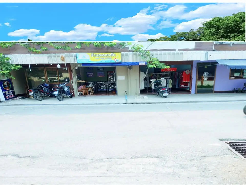 Charming street view of small shops with vibrant storefronts and motorcycles parked outside.