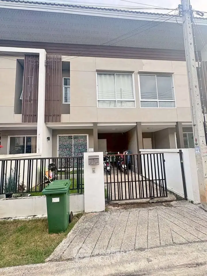 Modern two-story townhouse with gated driveway and contemporary facade.