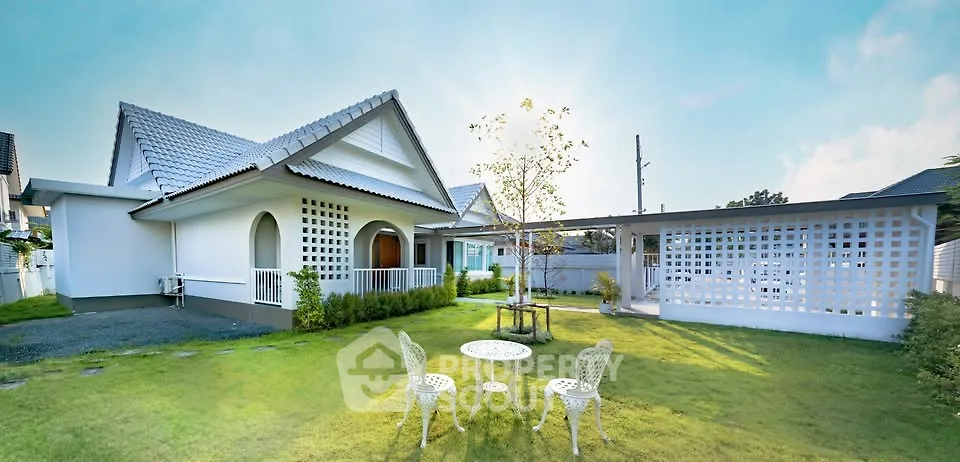 Charming suburban home with lush green garden and stylish outdoor seating area.
