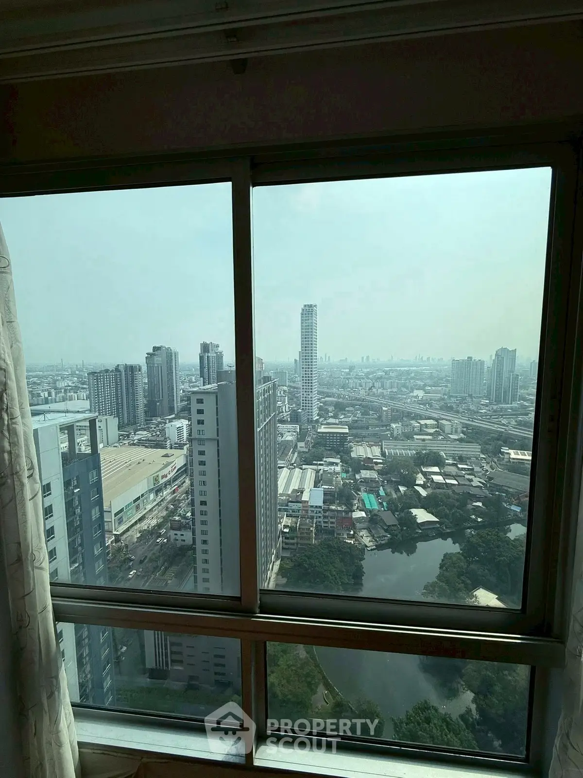 Stunning cityscape view from high-rise apartment window showcasing urban skyline.