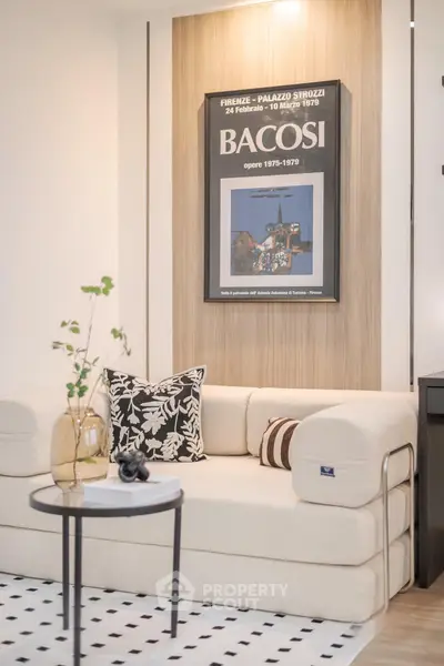 Stylish living room with modern beige sofa, artistic wall decor, and chic black and white accents.
