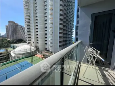Spacious balcony with stunning city view and tennis court access in modern high-rise building.