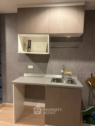 Modern compact kitchen with sleek cabinetry and stainless steel sink