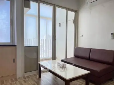 Modern living room with balcony access and sleek furniture design.