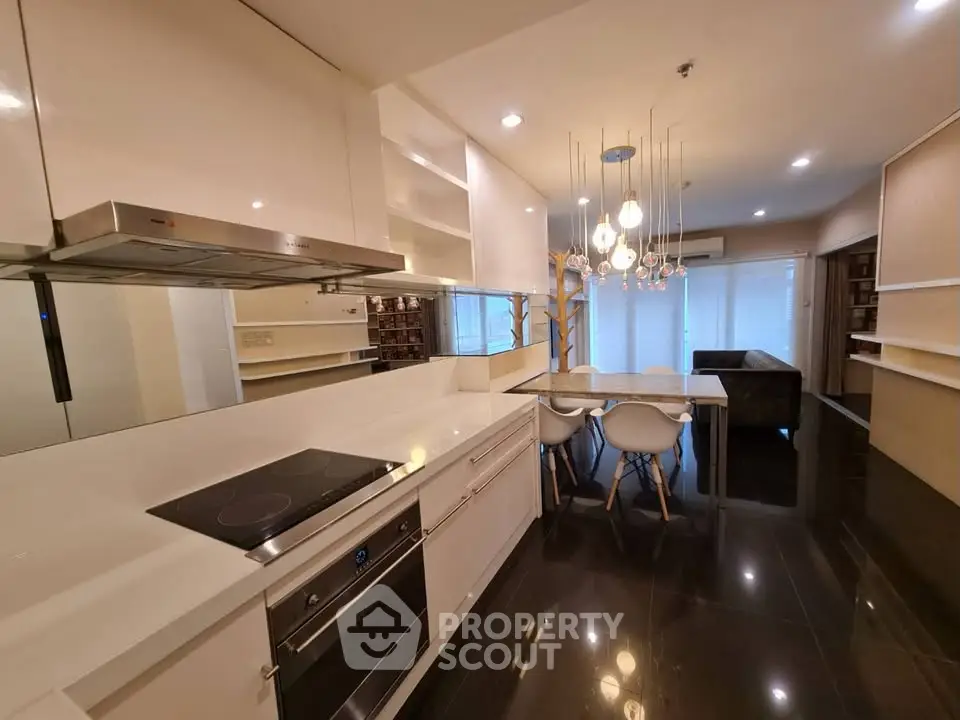 Modern open-layout kitchen with sleek design and dining area in a stylish apartment.