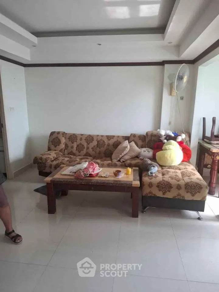 Cozy living room with patterned sofa and coffee table, perfect for relaxation.