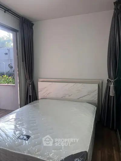 Cozy bedroom with new mattress and balcony access, perfect for relaxation and natural light.