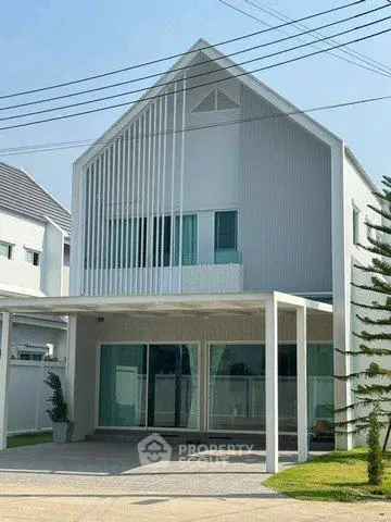 Modern two-story house with sleek design and large windows in a suburban neighborhood.