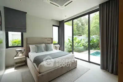 Luxurious bedroom with pool view and floor-to-ceiling windows in modern home