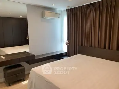 Modern bedroom with large bed, stylish furniture, and air conditioning