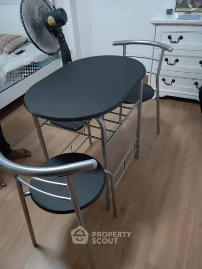 Cozy bedroom with compact dining set and wooden flooring