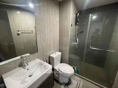 Modern bathroom with glass shower and sleek fixtures in contemporary apartment.