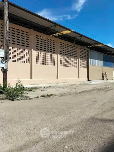 Spacious industrial warehouse exterior with secure gated entry and ample loading space.