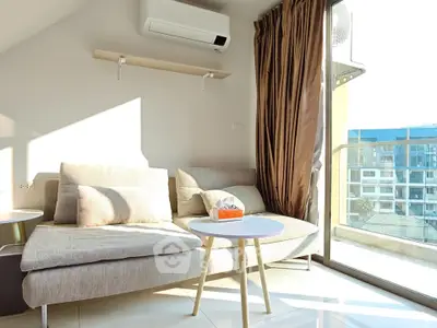 Bright modern living room with large windows and cozy sofa, perfect for relaxation.