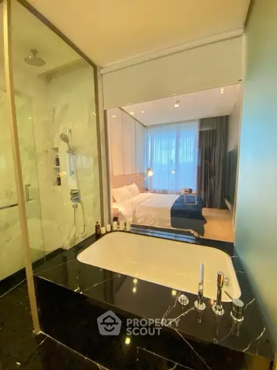 Luxurious bathroom with marble finishes and a view into a stylish bedroom, perfect for modern living.
