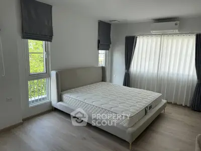 Spacious bedroom with modern design and large windows for natural light.