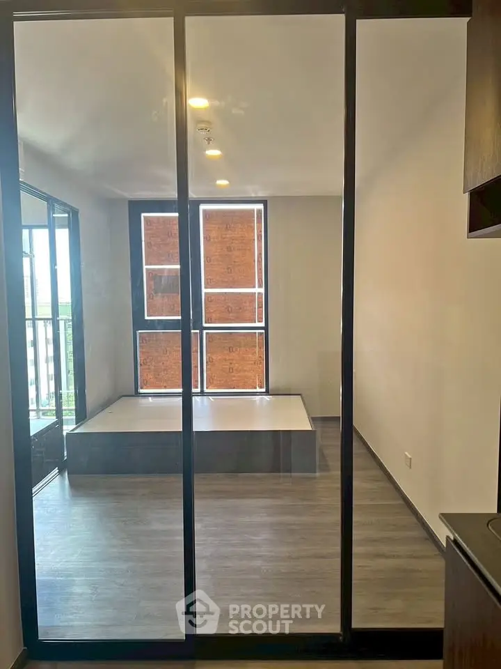 Modern bedroom with large windows and sleek flooring in a contemporary apartment.