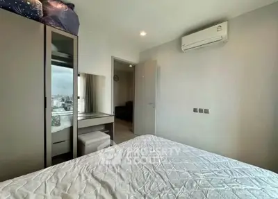 Modern bedroom with air conditioning and city view, featuring a sleek wardrobe and vanity area.