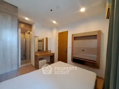 Modern bedroom with ensuite bathroom and wooden furniture in a stylish apartment.