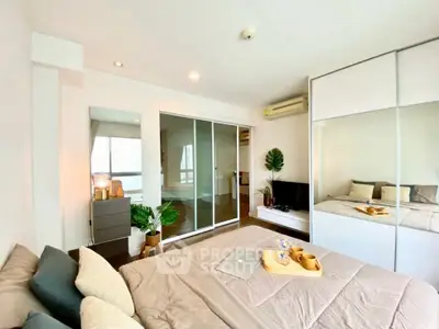 Modern bedroom with cozy decor, large mirror, and sliding wardrobe doors in a stylish apartment.