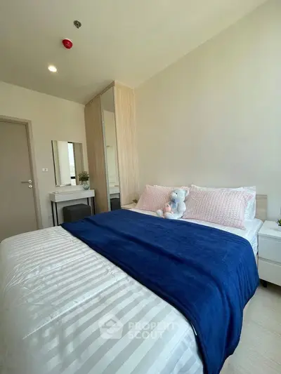 Cozy bedroom with modern decor and plush bedding in a stylish apartment.