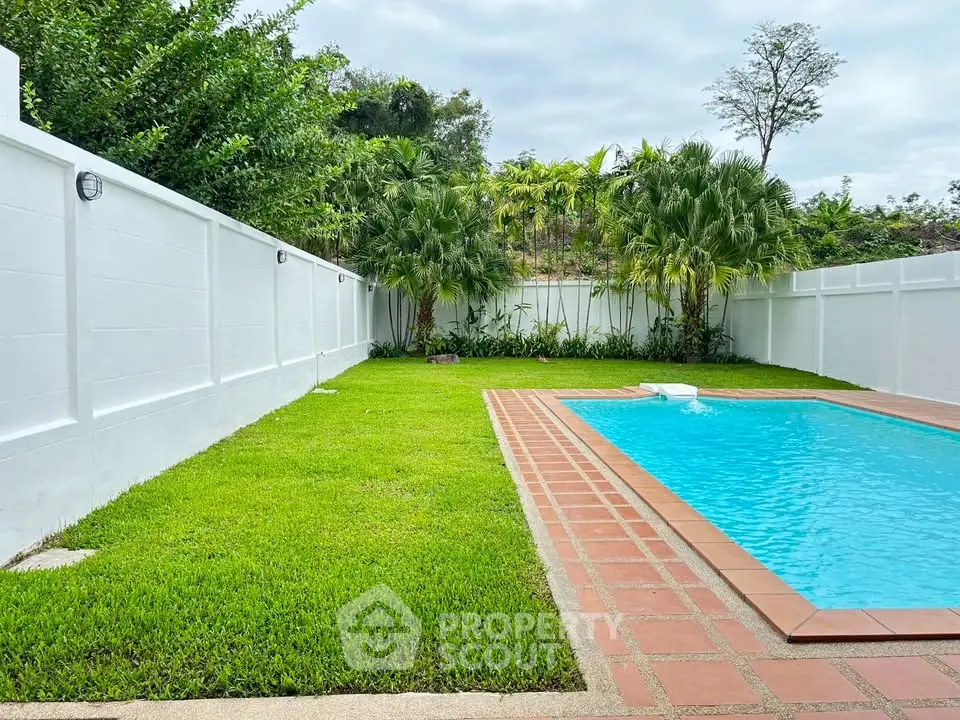 Spacious backyard with lush greenery and inviting swimming pool, perfect for relaxation and outdoor activities.