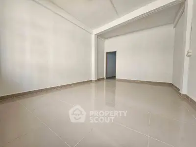 Spacious empty room with tiled flooring and white walls, ideal for customization.