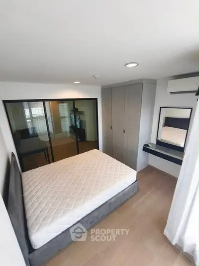 Modern bedroom with sleek design, featuring a comfortable bed, built-in wardrobe, and stylish vanity area.