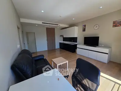 Modern living room with sleek furniture and wooden flooring in a stylish apartment.