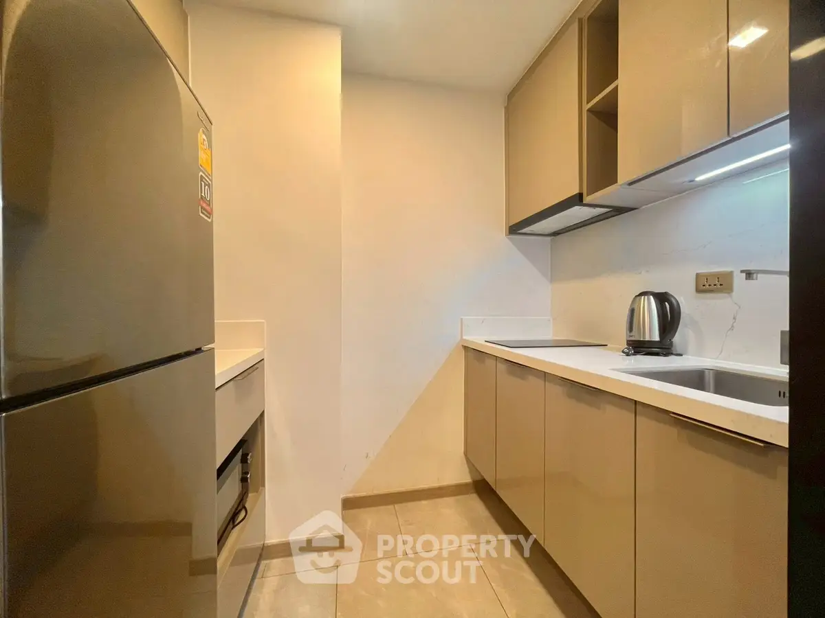 Modern kitchen with sleek cabinetry and stainless steel appliances in a contemporary apartment.