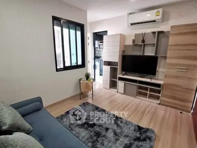 Modern living room with sleek furniture and air conditioning, featuring a cozy rug and entertainment unit.