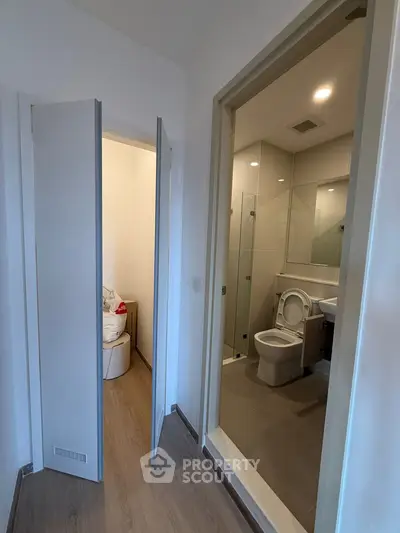 Modern bathroom with sleek design and adjacent storage area, featuring clean lines and neutral tones.