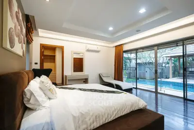 Luxurious bedroom with pool view and modern decor in a high-end property.