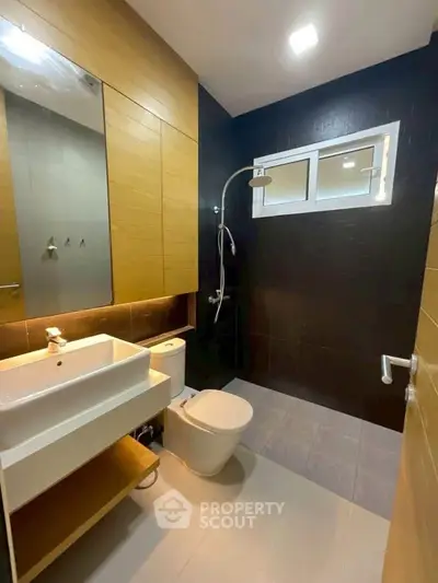Modern bathroom with sleek fixtures and stylish design, featuring a shower and vanity unit.