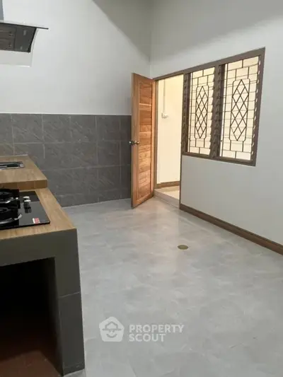 Modern kitchen with gas stove and wooden accents, featuring a closed layout and tiled walls.