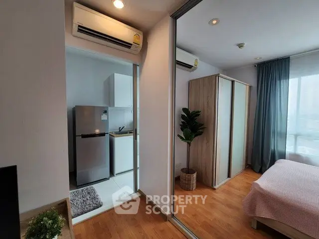 Modern apartment interior with bedroom and kitchen, featuring sleek design and natural light.