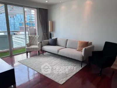 Modern living room with elegant furniture and city view balcony.
