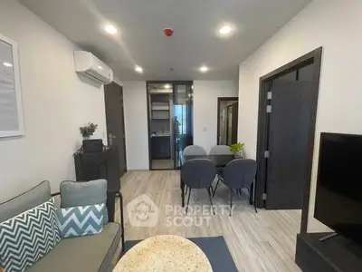 Modern living room with sleek furniture and dining area in open layout apartment.