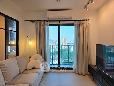 Modern living room with city view, cozy sofa, and large TV, perfect for relaxation and entertainment.