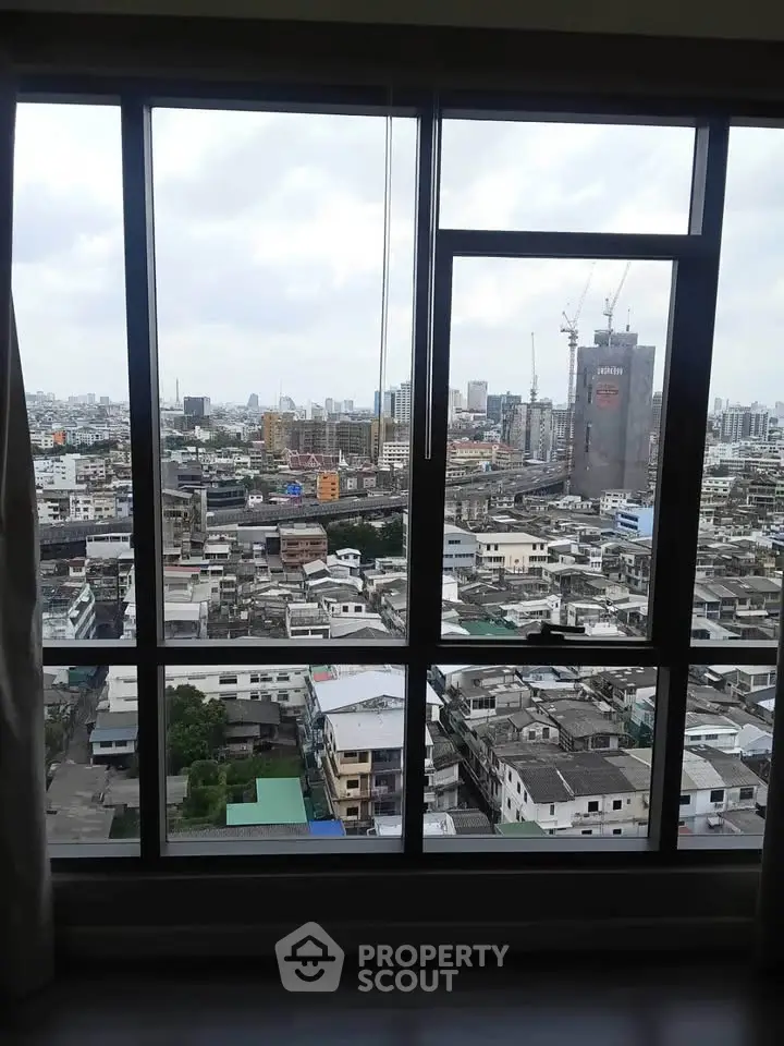 Stunning cityscape view from high-rise apartment window showcasing urban skyline.