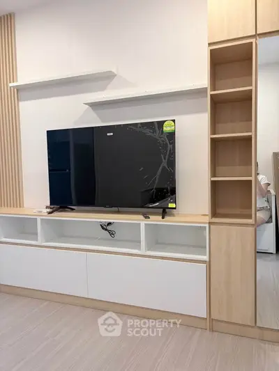 Modern living room with sleek TV unit and wooden shelving