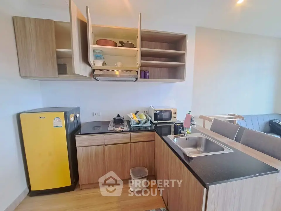 Modern kitchen with wooden cabinets and yellow fridge in cozy apartment