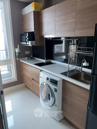 Modern kitchen with sleek wooden cabinets and built-in washing machine