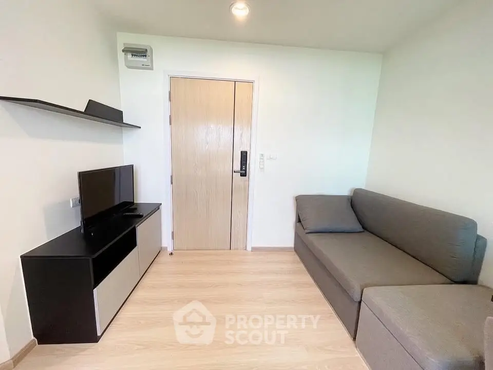 Modern living room with sleek furniture and wooden flooring, perfect for cozy relaxation.