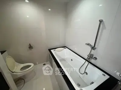 Modern bathroom with sleek white tiles and a luxurious bathtub, perfect for relaxation.