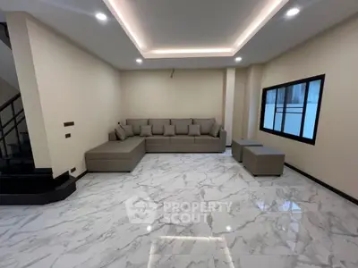 Spacious modern living room with elegant marble flooring and cozy sectional sofa.