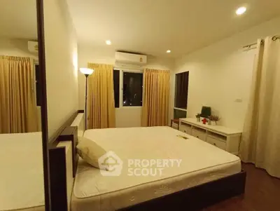 Cozy bedroom with large window and warm lighting, featuring a comfortable bed and elegant curtains.