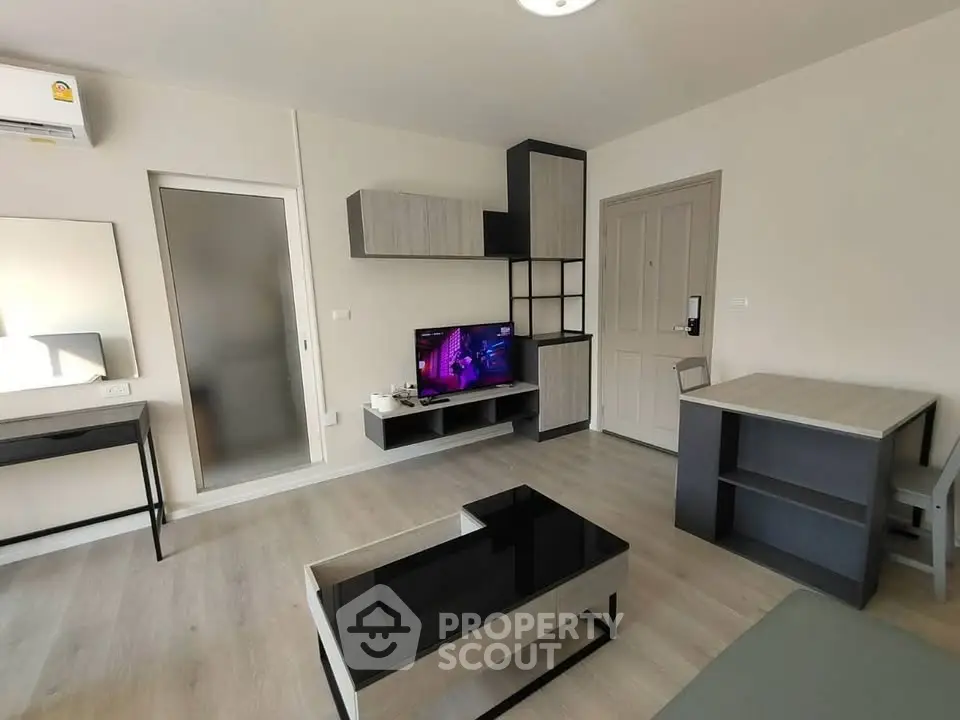 Modern living room with sleek furniture and wall-mounted TV in a stylish apartment.